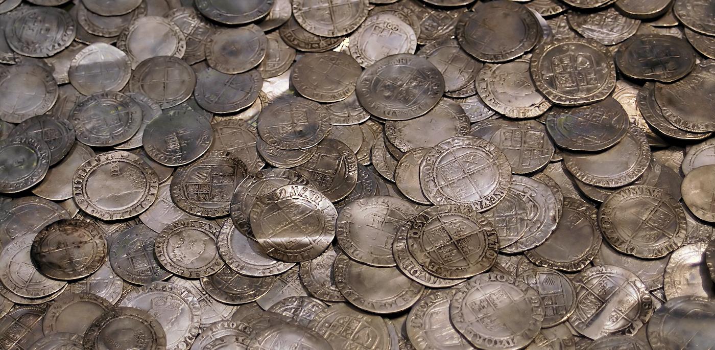 A hoard of struck silver coins, overlapping and filling the frame